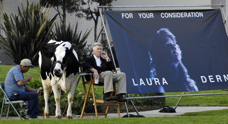 "Inland Empire" writer/director David Lynch (R) is joined by a live cow and its handler Mike Fanning as he promotes the film's star Laura Dern for movie awards season at the intersection of Hollywood Blvd. and La Brea Ave. in Los Angeles